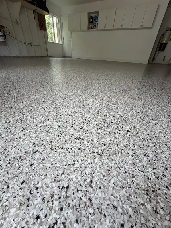 Close-up of the tan, grey, black and white Coyote flake blend on a Potomac garage floor