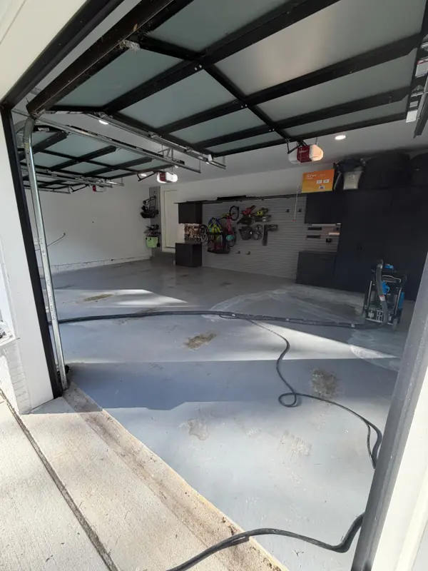 Worn grey garage floor in McLean during surface preparation, before the flake coating