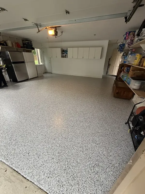Finished Coyote flake floor in a Potomac, MD two-car garage lined with storage shelves