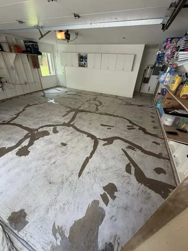 Prepared Potomac garage slab with dark patch lines visible before the flake broadcast