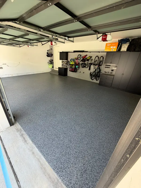 Finished Nightfall flake floor in a McLean garage bay with slatwall storage, bikes and dark cabinets