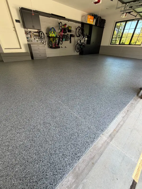 Close look at the grey, black and white Nightfall flake texture where the coating meets the garage door threshold in McLean