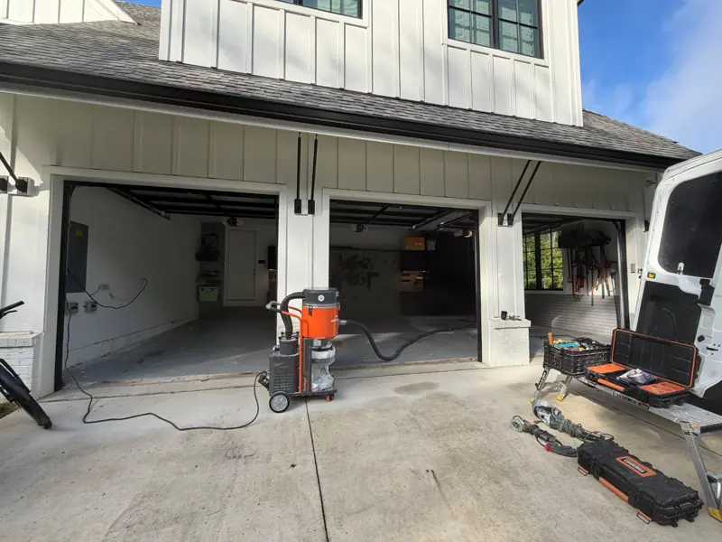 Three-car garage in McLean, VA with prep equipment on the driveway before the floor coating
