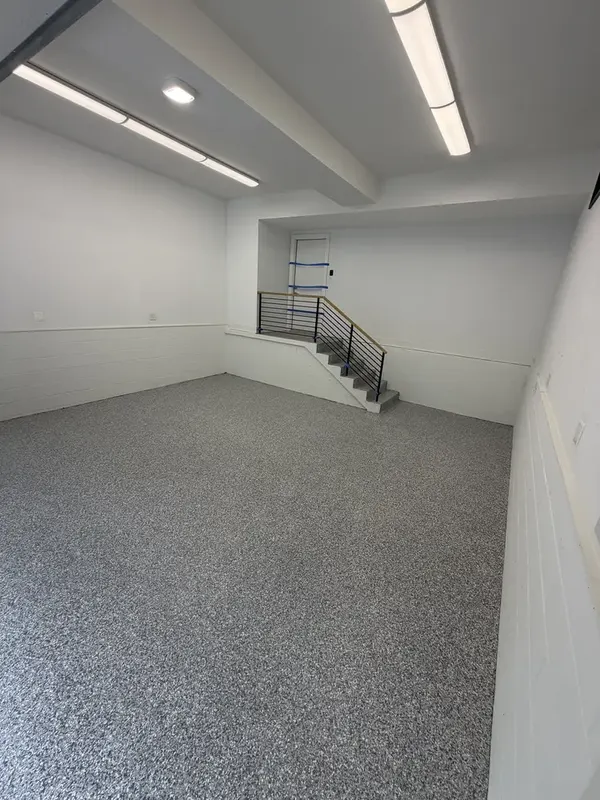 Finished Gravel flake floor in a bright Washington, DC garage with a staircase in the back corner