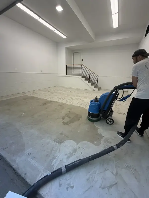 Crew member diamond grinding the bare concrete garage floor before coating in Washington, DC