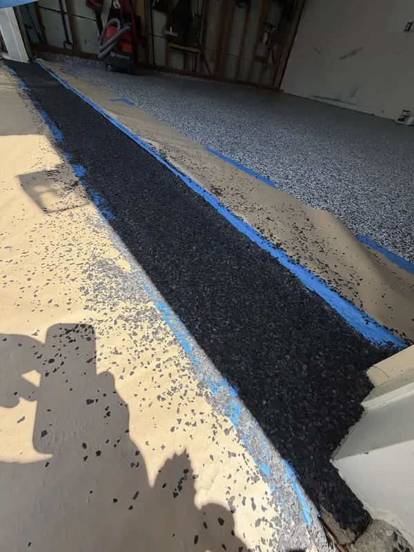Domino flakes being broadcast along the entrance edge of a Silver Spring, MD garage floor