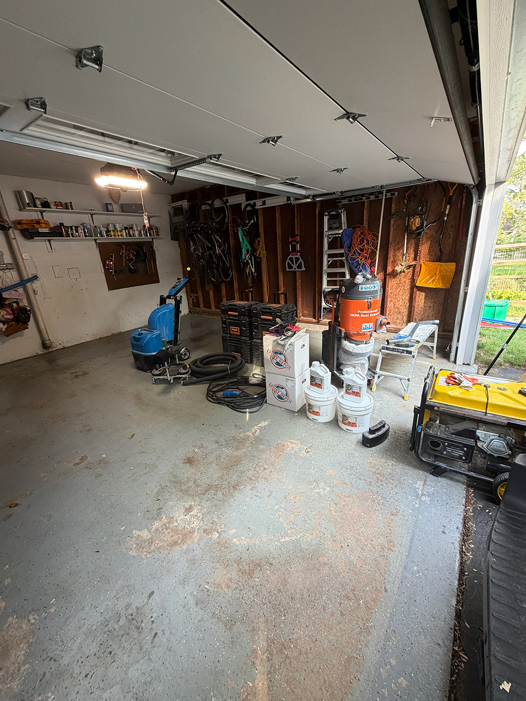 Concrete garage floor before coating — bare and stained