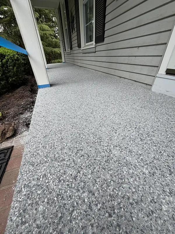 Husky Hybrid flake coating on a covered front porch in Herndon, VA, with white columns and grey siding