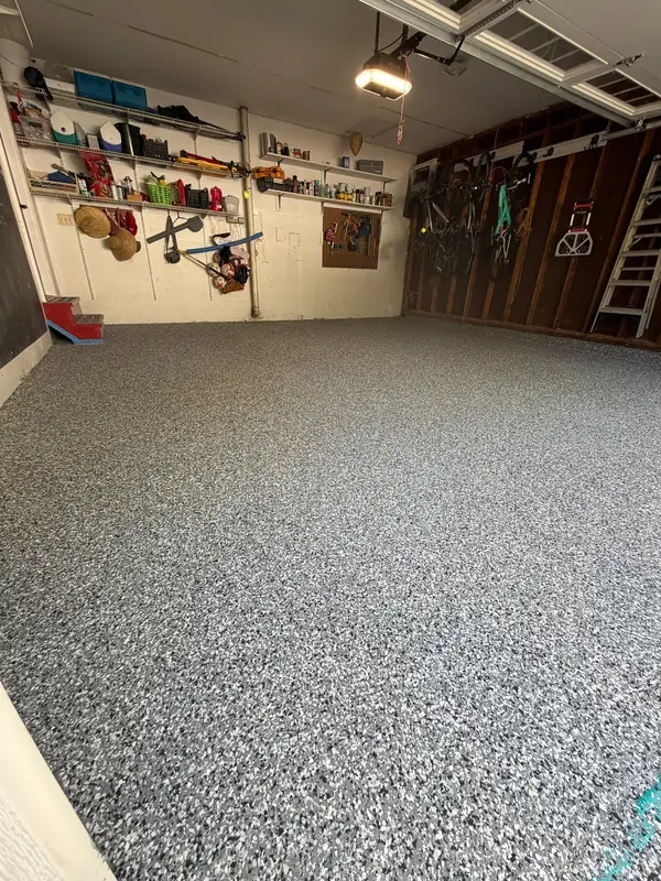 Finished Wombat flake floor in a Herndon, VA two-car garage with shelving and bikes on the walls
