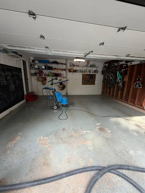Bare concrete in a Herndon, VA garage being diamond ground before the Wombat flake coating