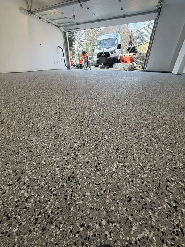 Low view across the Denali Hybrid flake floor toward the open garage door of a Washington, DC home